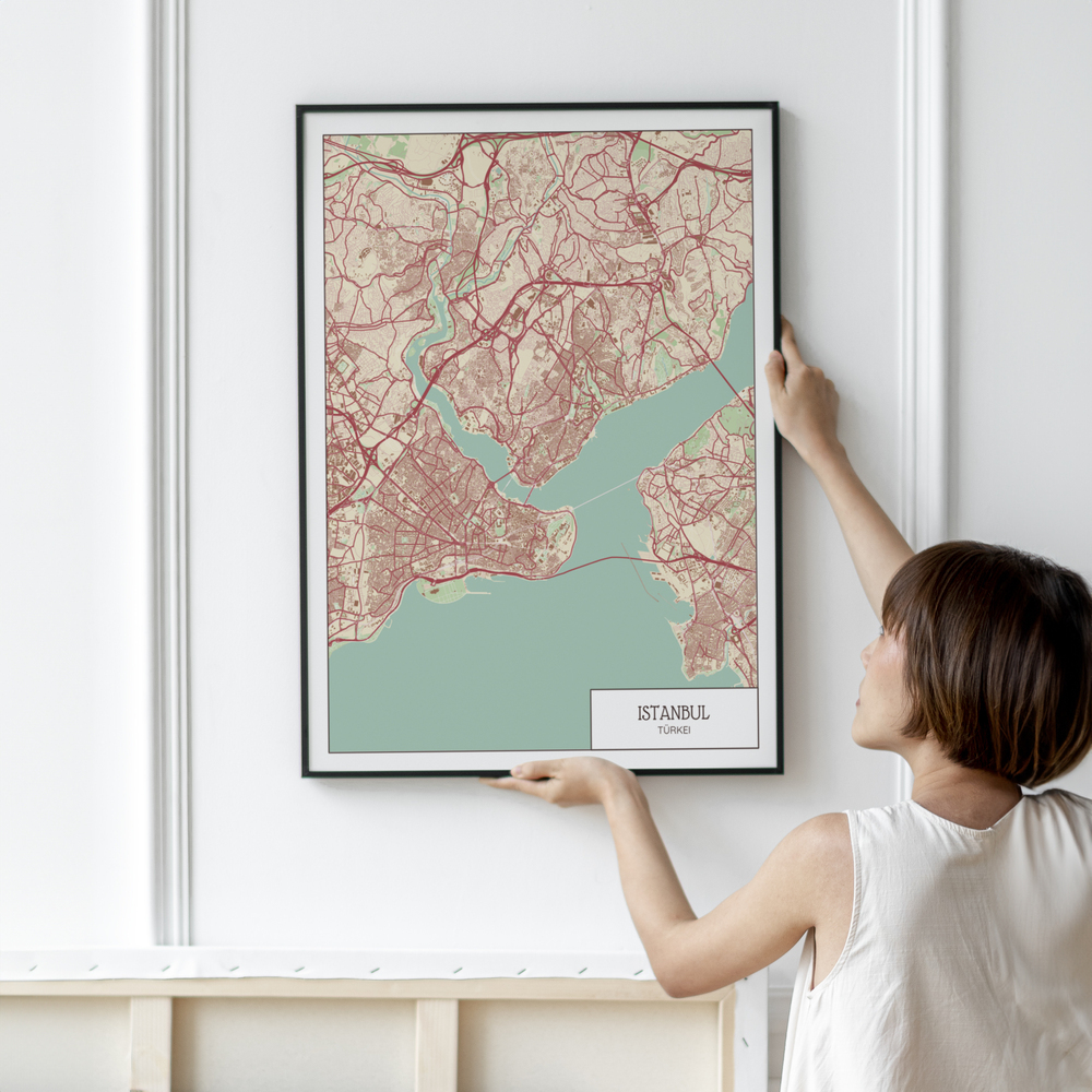 Grande poster della mappa di Istanbul rosso e verde menta, in cornice nera su una parete bianca con modanature