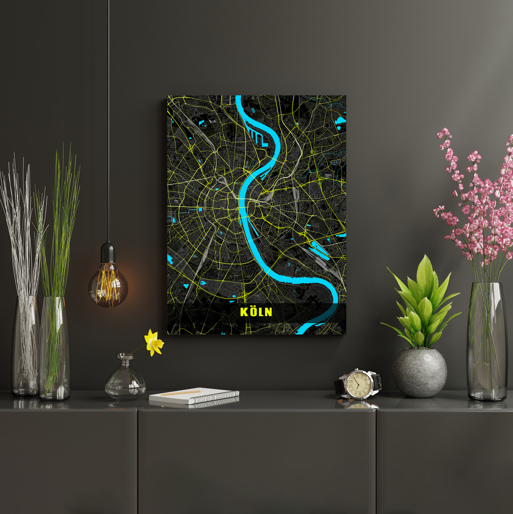 Mappa di Colonia in colori neon su una parete scura sopra una credenza, tra piante e una lampada a sospensione