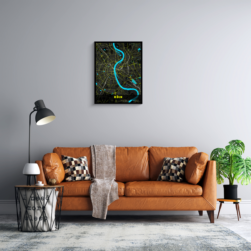 Mappa di Colonia in colori neon incorniciata sulla parete grigia del soggiorno, sopra un divano in pelle cognac