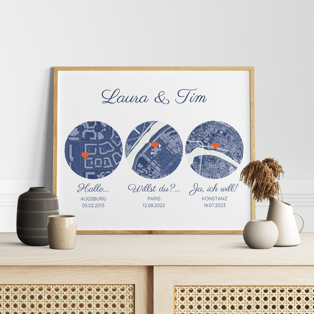 Kartenposter mit drei Orten und Herzmarkierungen im Naturholzrahmen auf einer Kommode als Geschenkidee zur Hochzeit
