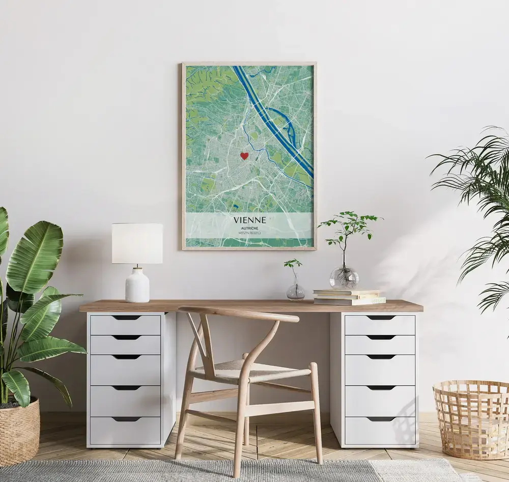 Affiche de plan de ville vert et bleu avec coordonnées et repère cœur, encadrée en bois au-dessus du bureau
