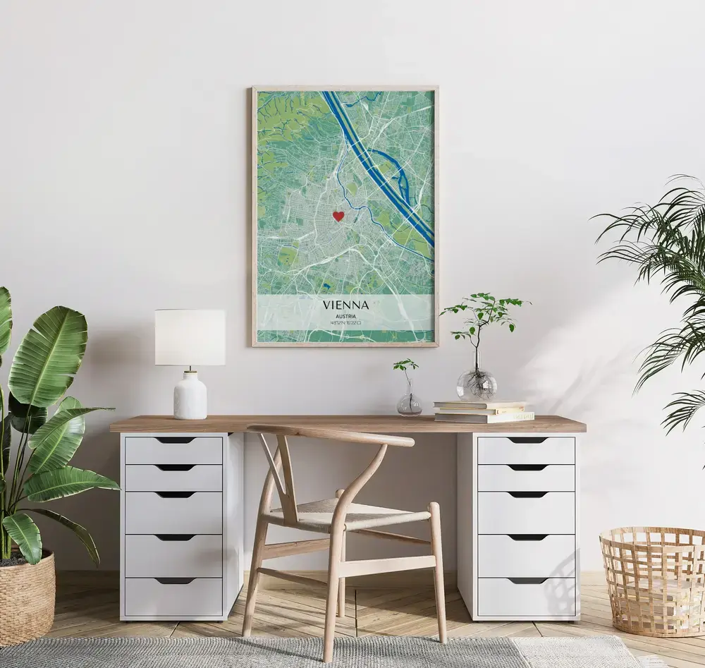 Poster con mappa della città verde e blu, coordinate e segnaposto a cuore, in cornice di legno sopra la scrivania