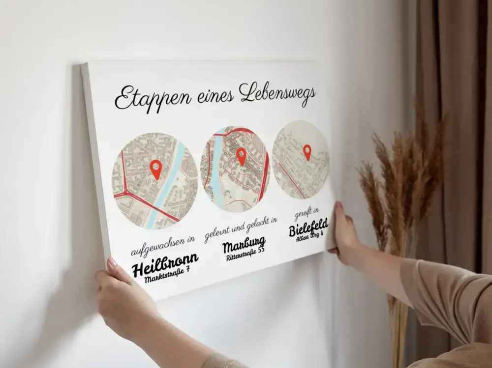 Lebensweg-Karte mit drei markierten Orten an heller Wand neben Trockenblumen als Geschenkidee für den Partner